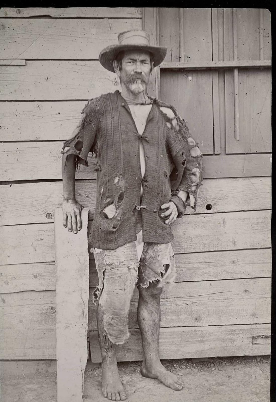 Trabajador posando frente a una construcción de madera