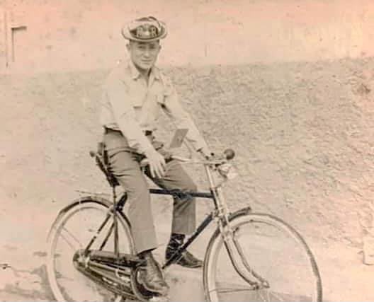 Hombre uniformado posando junto a una bicicleta