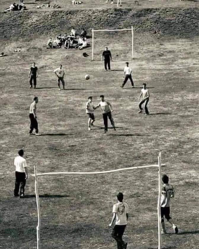 Personas jugando en una cancha de tierra