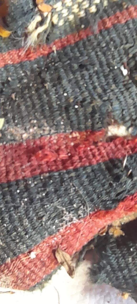 Detalle de tejido en tonos oscuros y rojos